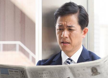 日経新聞を読んでいる男性