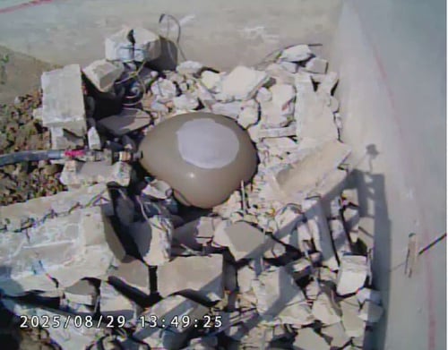 道路陥没用ゴム球体に流動化処理土を注入している写真（突起物に当たっても割れずに追従している）