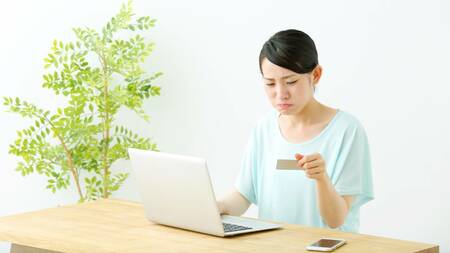 クレジットカードを照らし合わせる女性