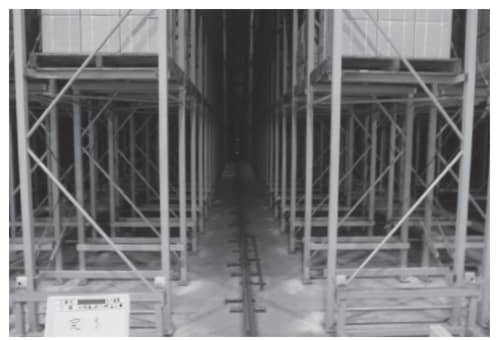 自動収納ラックが林立し、床にレールが走っている倉庫