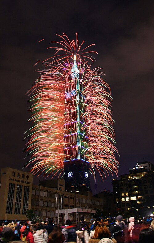 総統選が目前に迫る中、新年を祝う台北101の花火を見上げる人々