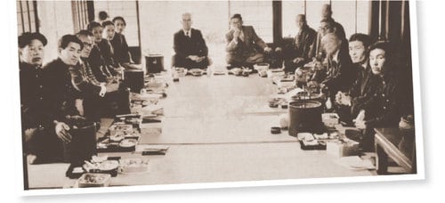 昭和10年代の宴会風景（左も）。N家での接待のご馳走は、自宅でニワトリを調理し、「トリすき鍋」にすることが多かった。こういった宴席に、書画骨董が飾られた。たびたび宴会が行われたために、書画骨董は1セットでは足りず、複数買い求める必要があった。床の間に掛け軸が見える。写真／個人蔵