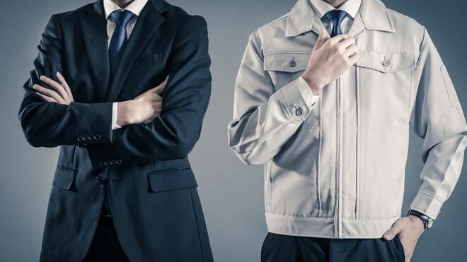 並んで立つスーツを着た人物と作業着を着た人物