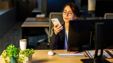 夜にスマホを操作している女性