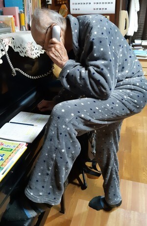 片足をピアノの椅子にのっけて石原裕次郎ばりのポーズで電話中のじーじ。写真提供=黒川玲子
